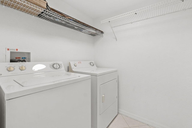 1801 N Flagler Dr Unit 828, West Palm Beach, FL 33407 - laundry room featuring washer and clothes dryer, light tile patterned floors, and baseboards