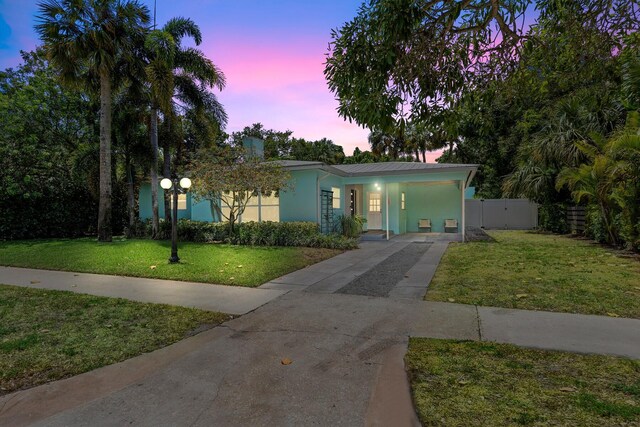 view of front of home with covered porch, stucco siding, concrete driveway, and a front yard