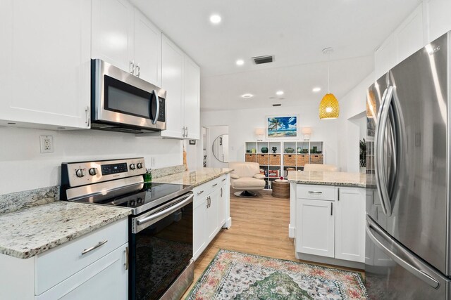kitchen featuring stainless steel appliances, visible vents, white cabinetry, and light wood-style floors