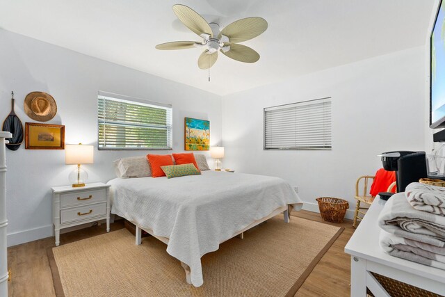 bedroom with light wood-type flooring, baseboards, and ceiling fan