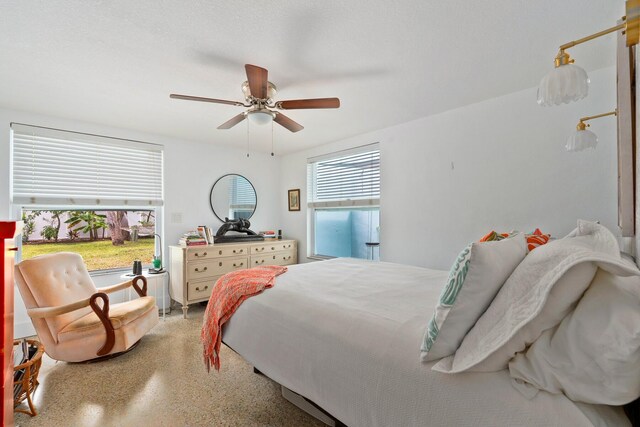 bedroom featuring a ceiling fan, speckled floor, and multiple windows
