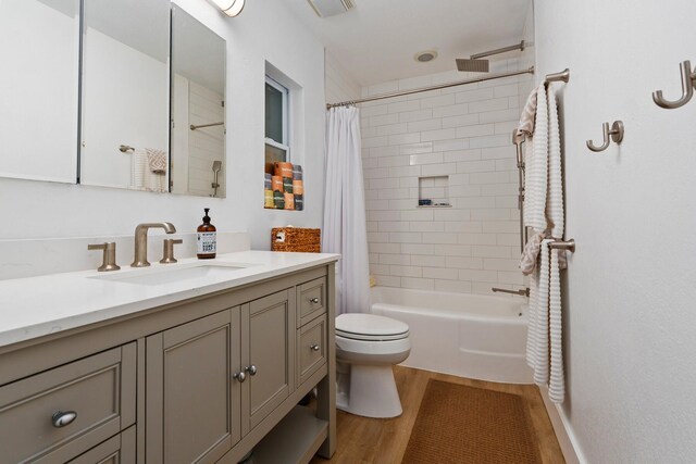 full bathroom with vanity, toilet, wood finished floors, and shower / tub combo with curtain