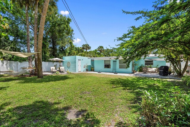 view of front facade featuring stucco siding, a patio area, fence, and a front yard