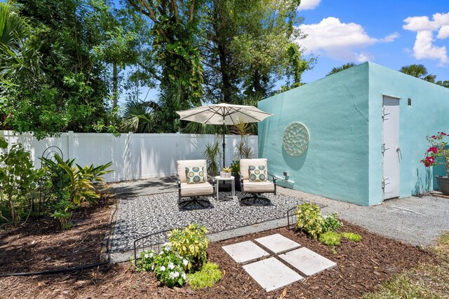 view of patio / terrace featuring fence and an outbuilding