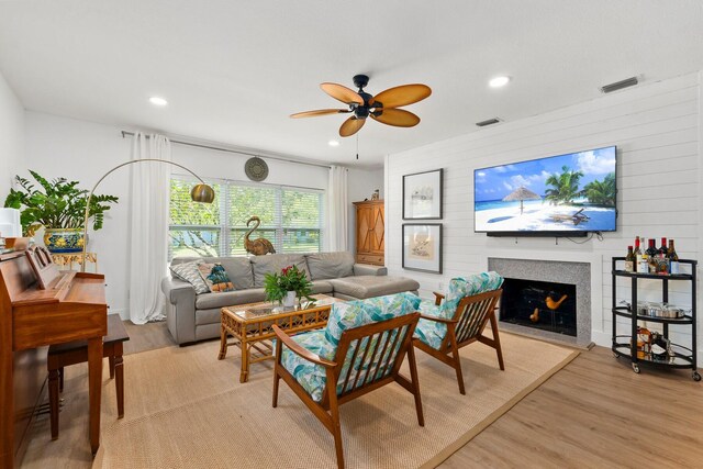 living room with light wood finished floors, a fireplace, a ceiling fan, recessed lighting, and visible vents