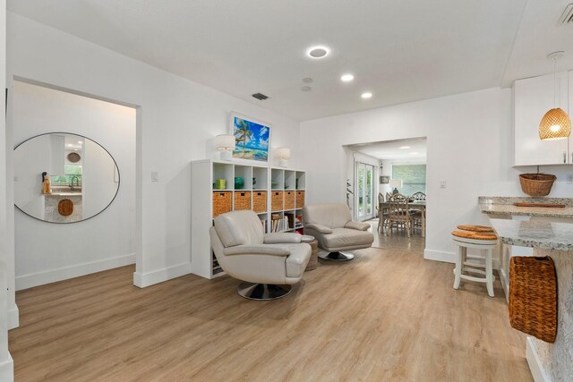 living area with visible vents, recessed lighting, light wood-style flooring, and baseboards