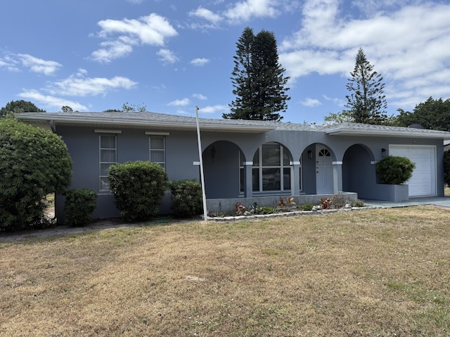 ranch-style home with an attached garage, stucco siding, and a front yard