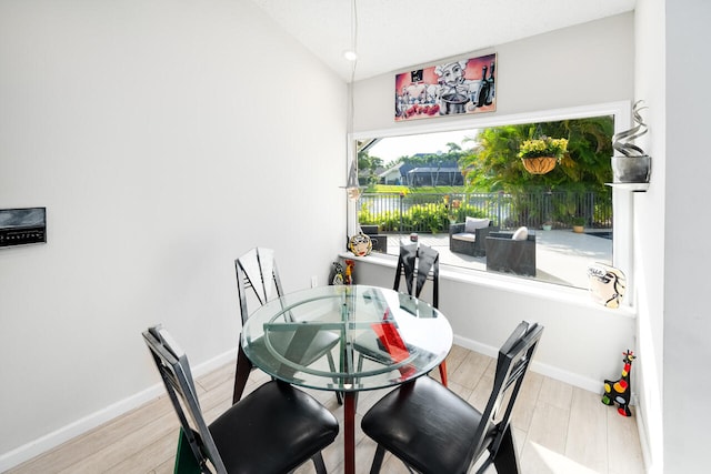dining area with baseboards and wood finished floors