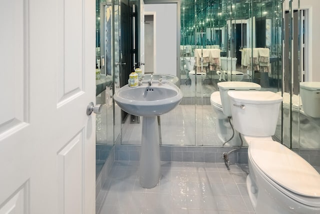 bathroom featuring tile patterned floors, toilet, and a bidet