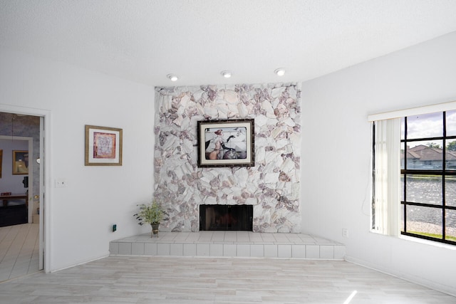 unfurnished living room featuring baseboards, a fireplace, and wood finished floors