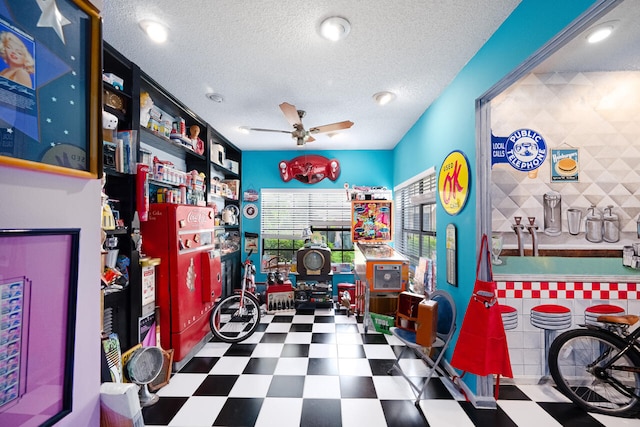 recreation room with a textured ceiling, tile patterned floors, recessed lighting, and ceiling fan