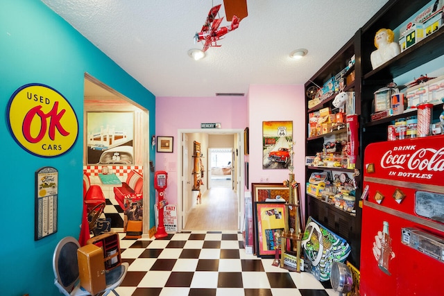 rec room with a textured ceiling, tile patterned floors, and visible vents