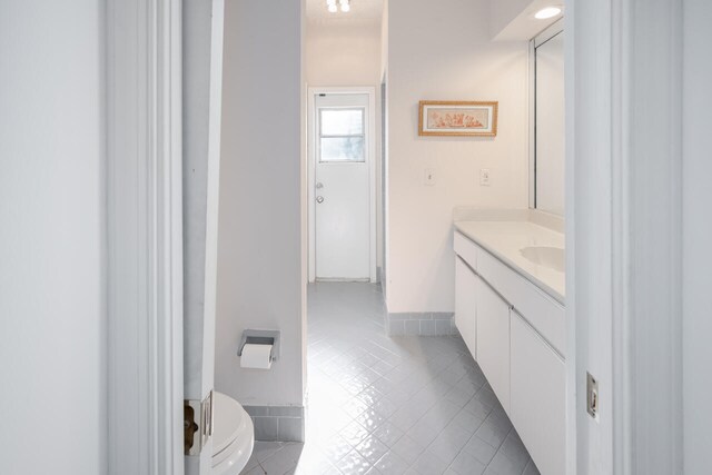 bathroom featuring tile patterned floors, baseboards, and vanity