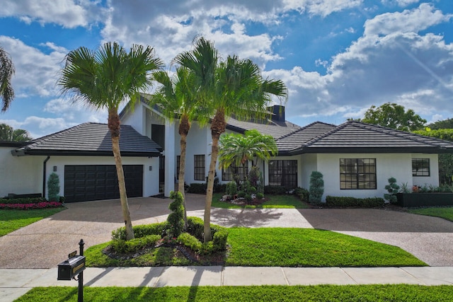 view of front of house with a garage, stucco siding, a tile roof, and concrete driveway
