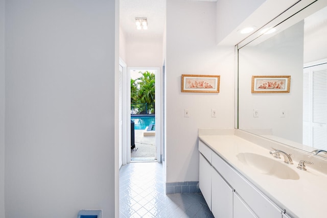 bathroom with tile patterned flooring, baseboards, and vanity