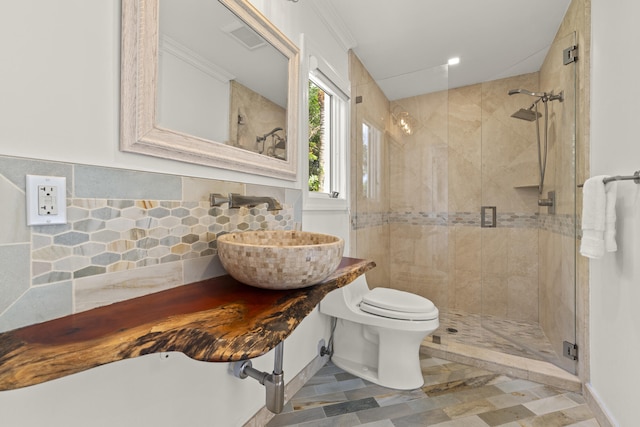 103 River Dr, Tequesta, FL 33469 - bathroom featuring a sink, a shower stall, toilet, and decorative backsplash