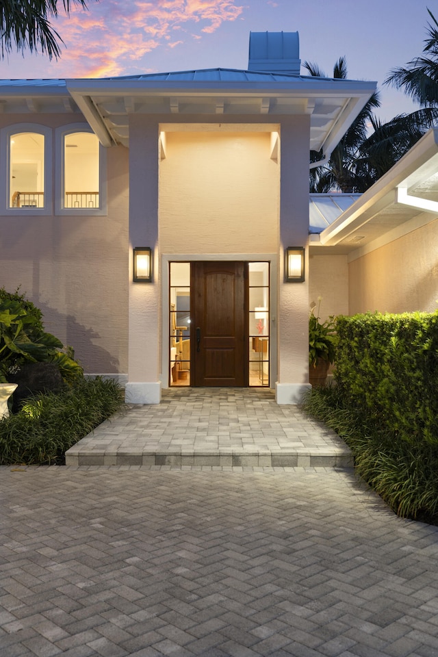 103 River Dr, Tequesta, FL 33469 - exterior entry at dusk featuring stucco siding