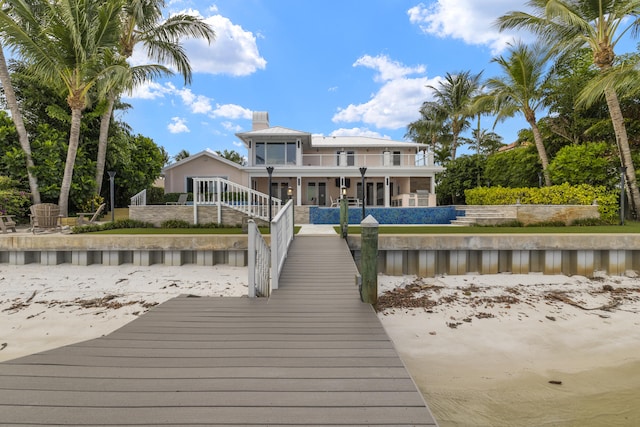 103 River Dr, Tequesta, FL 33469 - back of house with a balcony, a chimney, and a water view