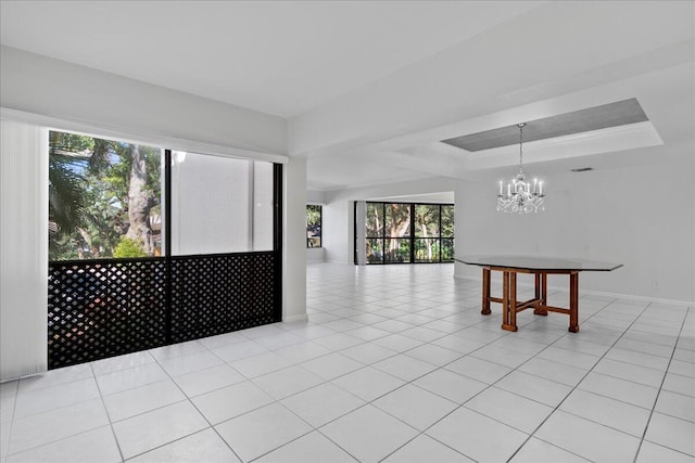 1640 Twelve Oaks Way Unit 205, North Palm Beach, FL 33408 - empty room with light tile patterned floors, baseboards, a tray ceiling, and a chandelier