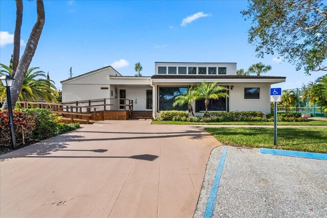 1640 Twelve Oaks Way Unit 205, North Palm Beach, FL 33408 - view of front of property with covered porch, stucco siding, and a front lawn