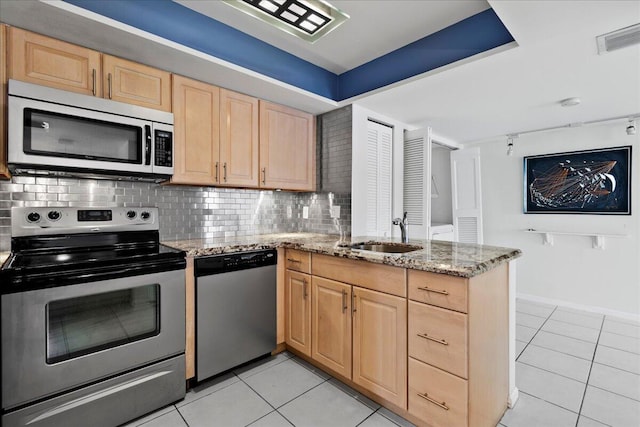 1640 Twelve Oaks Way Unit 205, North Palm Beach, FL 33408 - kitchen with a sink, light tile patterned floors, a peninsula, light brown cabinets, and stainless steel appliances