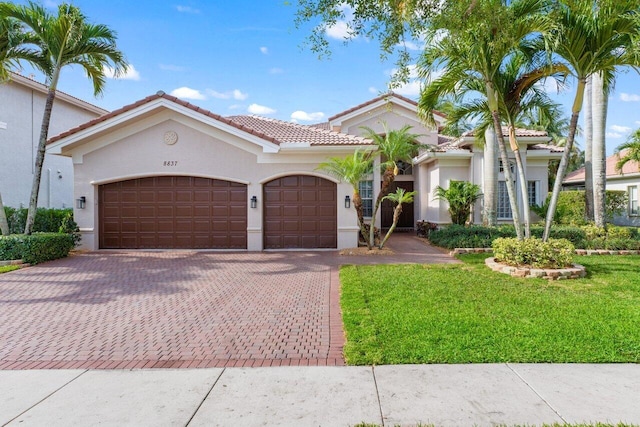 8837 Woodgrove Ridge Ct, Boynton Beach, FL 33473 - mediterranean / spanish-style home featuring a garage, stucco siding, a tiled roof, and decorative driveway