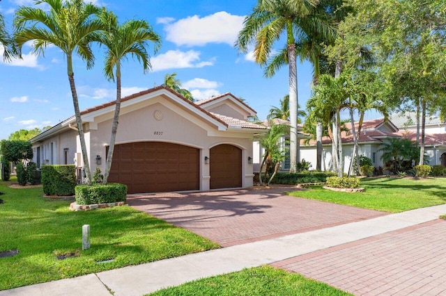 8837 Woodgrove Ridge Ct, Boynton Beach, FL 33473 - mediterranean / spanish-style home with a tiled roof, a garage, decorative driveway, a front lawn, and stucco siding