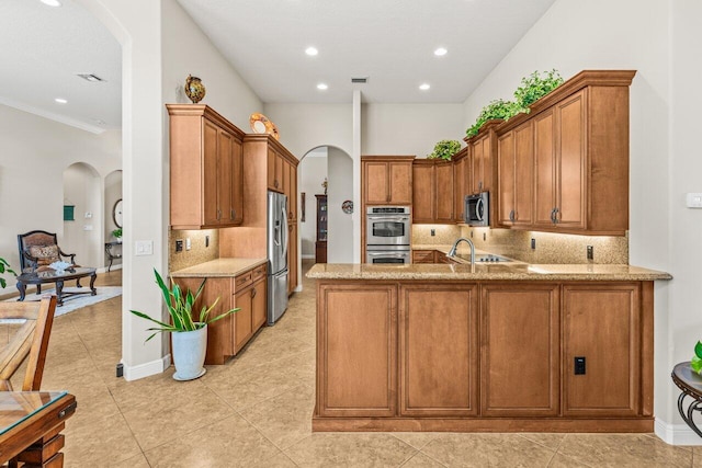 8837 Woodgrove Ridge Ct, Boynton Beach, FL 33473 - kitchen with arched walkways, a peninsula, light stone countertops, and stainless steel appliances