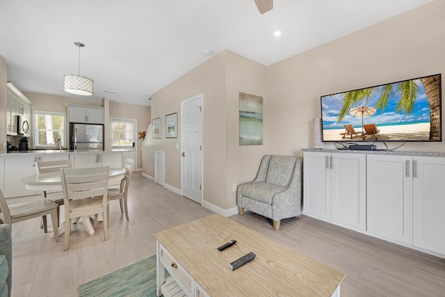 living area with baseboards and recessed lighting