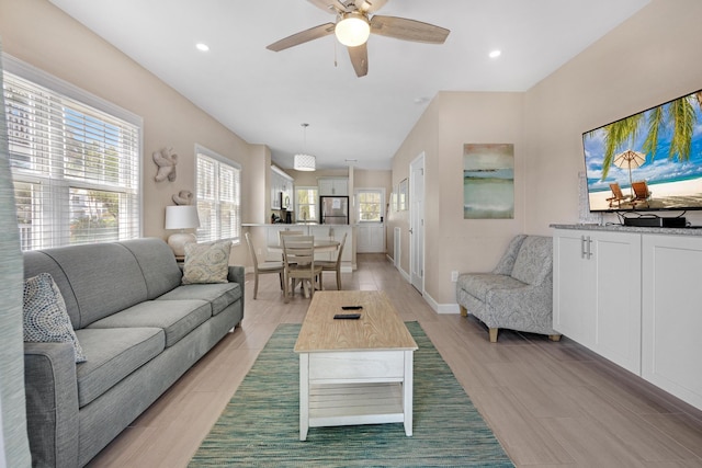 living room with baseboards, ceiling fan, and recessed lighting