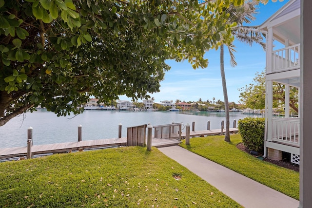 exterior space with a boat dock, a water view, and a yard