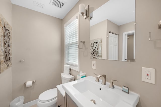 bathroom featuring toilet, visible vents, and vanity
