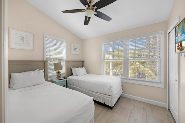 bedroom with baseboards, multiple windows, and vaulted ceiling