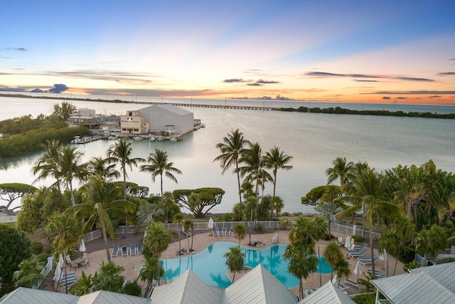 aerial view at dusk featuring a water view
