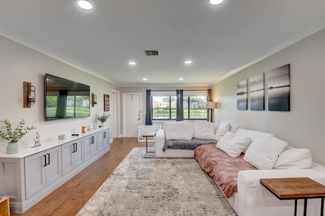 living room featuring recessed lighting, visible vents, ornamental molding, and light wood-style floors