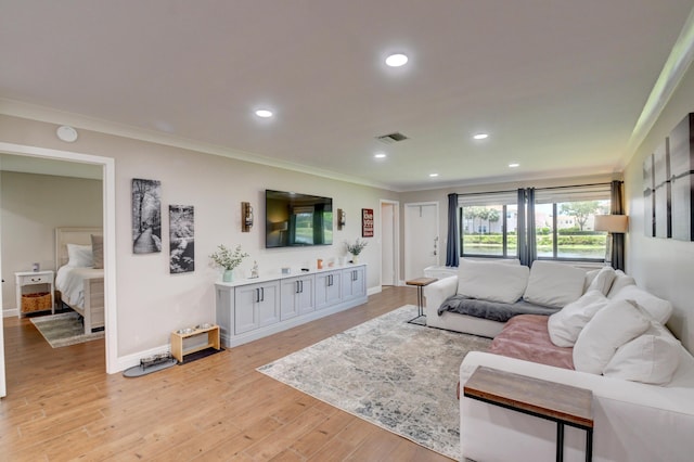 living room featuring visible vents, baseboards, light wood-style floors, ornamental molding, and recessed lighting