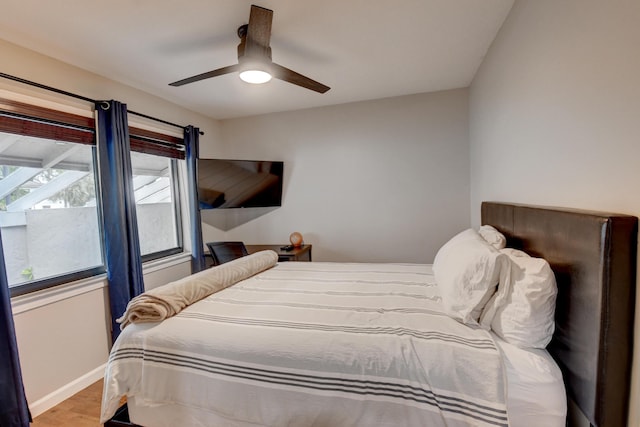 bedroom with baseboards, ceiling fan, and wood finished floors