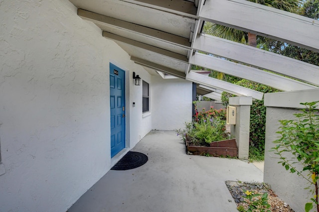 doorway to property featuring stucco siding