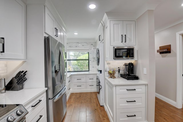 kitchen featuring decorative backsplash, light wood-type flooring, stainless steel appliances, recessed lighting, and white cabinetry