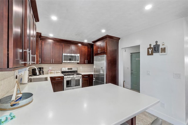 kitchen featuring decorative backsplash, appliances with stainless steel finishes, a sink, light countertops, and recessed lighting