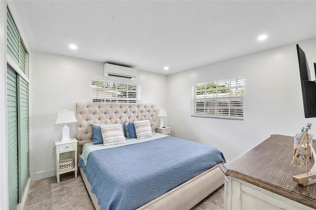 bedroom featuring baseboards, a wall unit AC, and recessed lighting