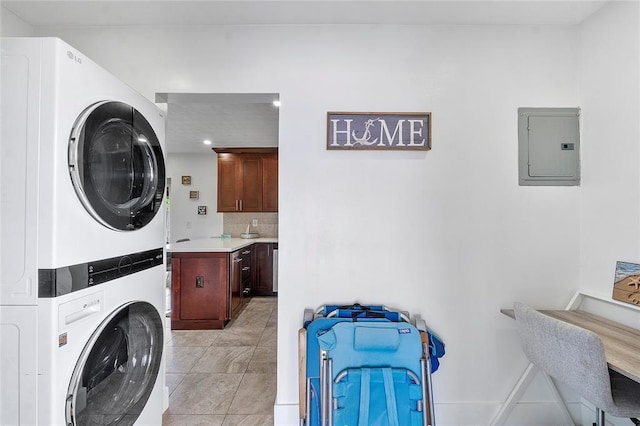 laundry room featuring laundry area, electric panel, stacked washer and clothes dryer, recessed lighting, and light tile patterned flooring