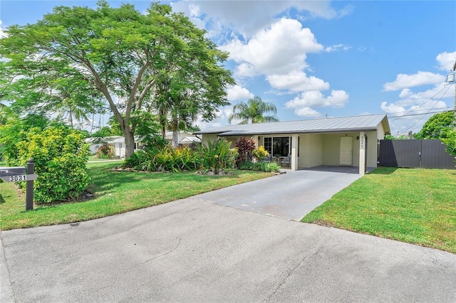 single story home with stucco siding, driveway, a front yard, and metal roof