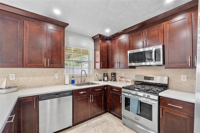 kitchen with a sink, appliances with stainless steel finishes, light tile patterned flooring, and light countertops