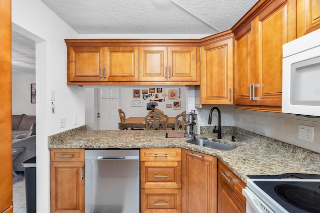 712 Sunny Pine Way Unit D1, Greenacres, FL 33415 - kitchen with brown cabinets, white microwave, a sink, tasteful backsplash, and stainless steel dishwasher