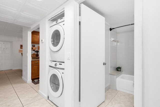 712 Sunny Pine Way Unit D1, Greenacres, FL 33415 - clothes washing area featuring light tile patterned floors, baseboards, and stacked washer and dryer