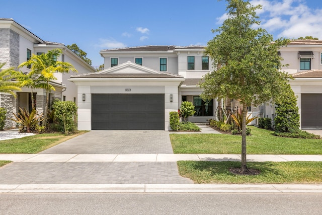 13158 Artisan Cir, Palm Beach Gardens, FL 33418 - view of front of home with stucco siding, decorative driveway, a garage, a front yard, and a tile roof
