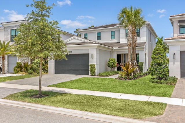 13158 Artisan Cir, Palm Beach Gardens, FL 33418 - view of front facade featuring a front yard, stucco siding, driveway, an attached garage, and a tiled roof