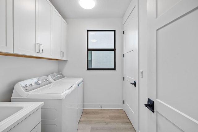 13158 Artisan Cir, Palm Beach Gardens, FL 33418 - washroom with washer and clothes dryer, cabinet space, light wood finished floors, and baseboards