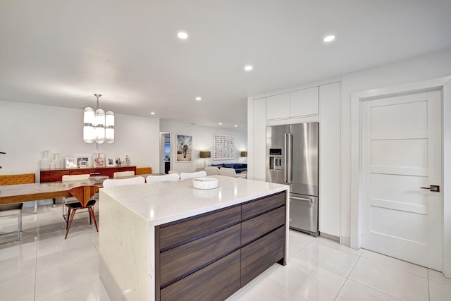 kitchen with an inviting chandelier, modern cabinets, recessed lighting, light tile patterned floors, and high quality fridge